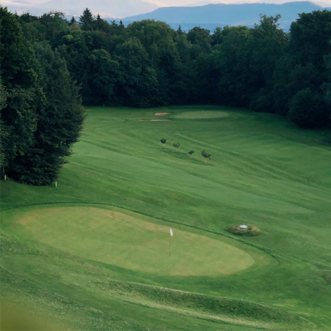 Aerial view across wooded golf course